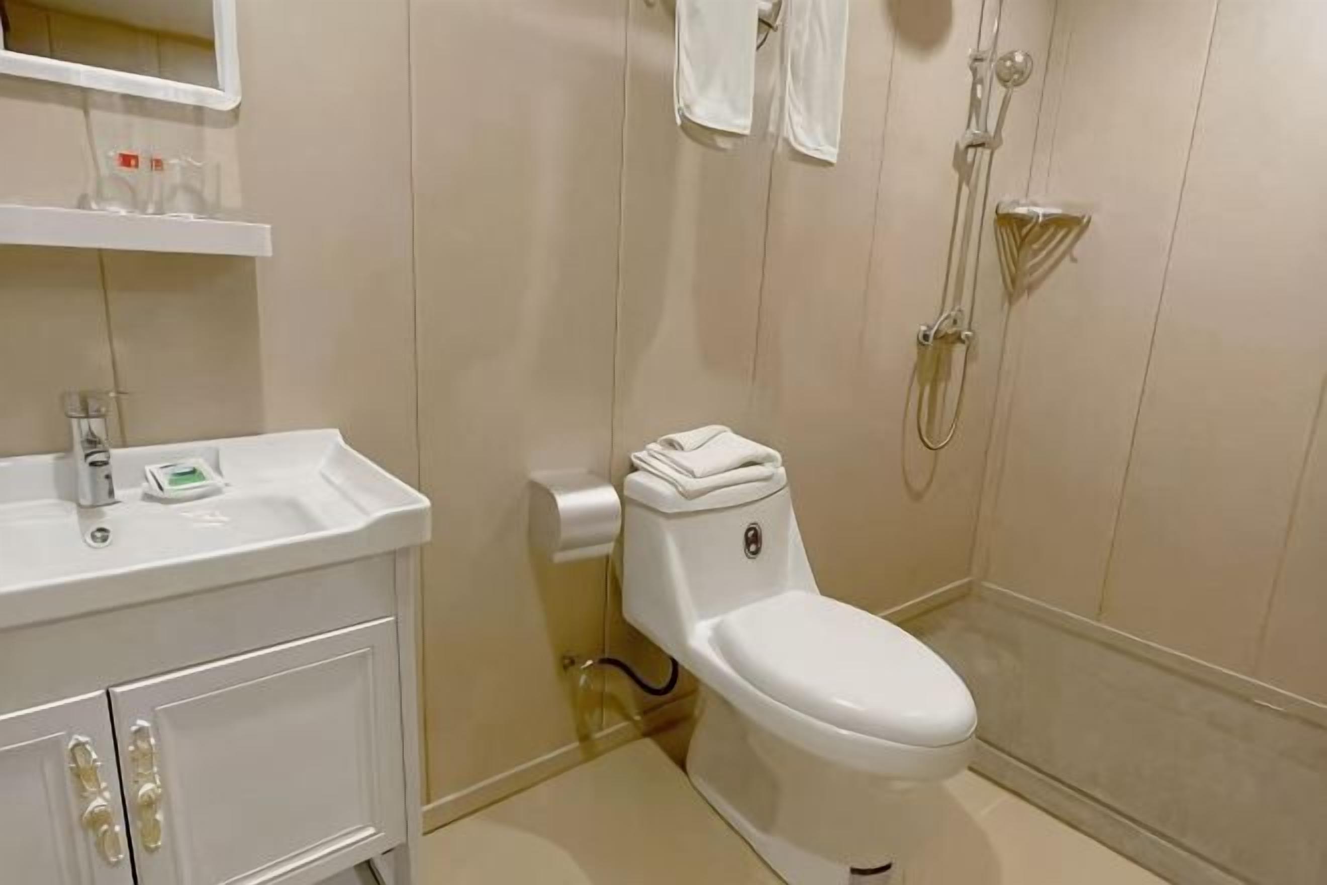 A bathroom with a white sink, toilet, and shower.