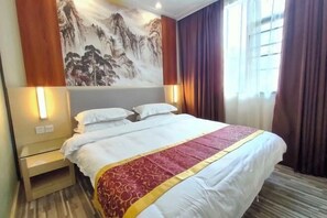 A hotel room with a bed, nightstand, wall art, and a window with curtains. - Yiru Express Apartment Hotel（Shantou's long corridor on the seaside) (Shantou)