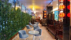 A corridor with seating areas, bamboo plants, and traditional lanterns. - Yiru Express Apartment Hotel（Shantou's long corridor on the seaside) (Shantou)