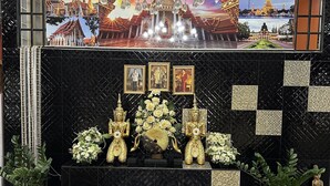 Un área de recepción con pared de baldosas negras, un candelabro y un cartel grande con un templo.