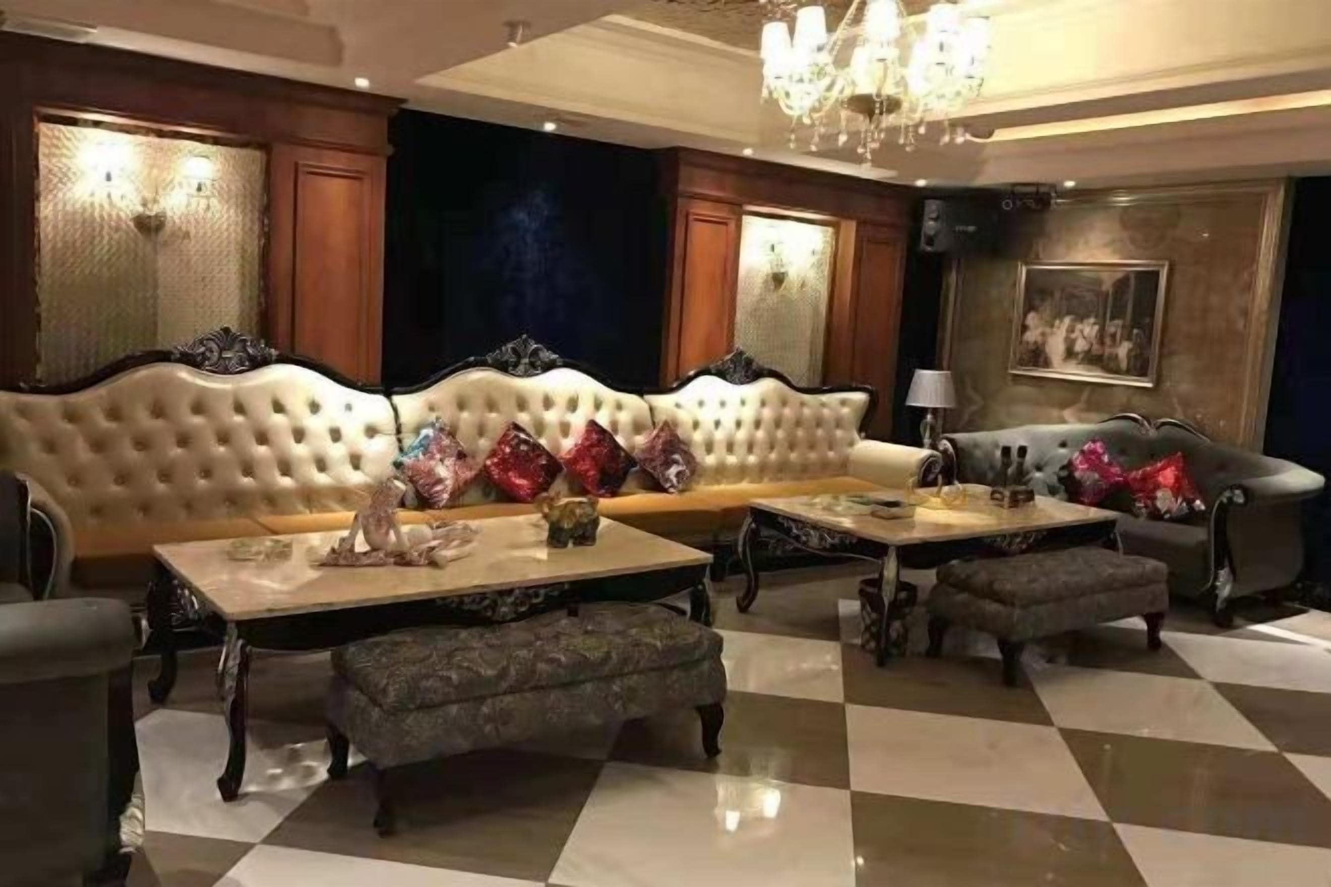 Una sala de estar lujosa con un sofá grande, dos sillones, una mesa de centro y un reposapiés estampado.