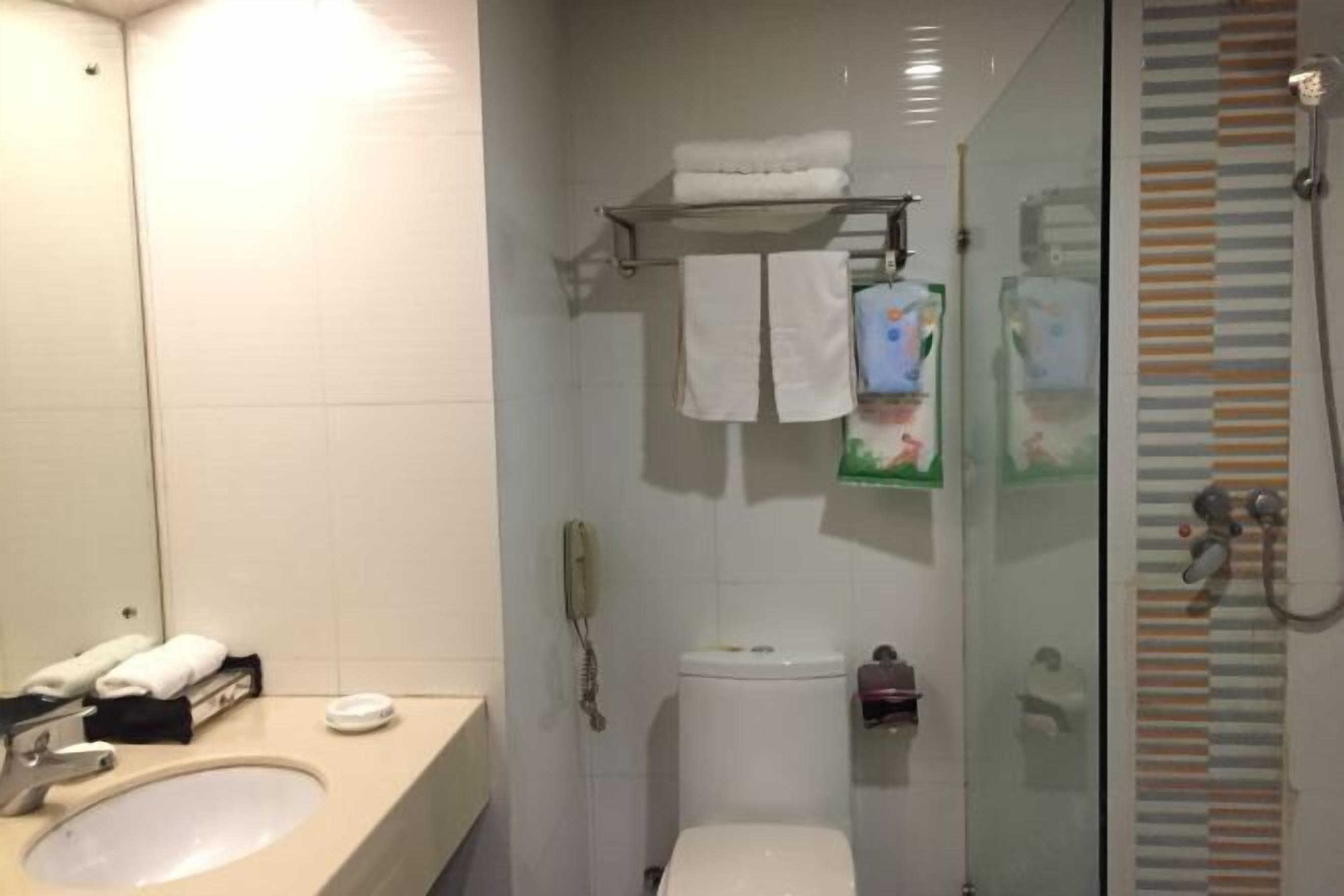 A bathroom with a sink, toilet, and glass-enclosed shower area.