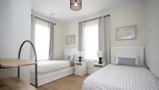 Un dormitorio con dos camas, una mesita y una silla.