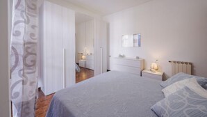 Una camera da letto con un letto, un comodino, una cassettiera e uno specchio a parete.