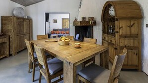 A rustic dining area with a wooden table and chairs, a fruit bowl, and a fireplace. - Villa Romana by Interhome (Porto Vecchio)