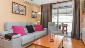 A modern living room with a grey sofa, a wooden coffee table, and a dining area with a table and chairs. - Apartment Silves by Interhome (Tossa de Mar)