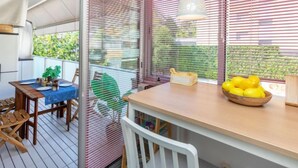 A dining area with a table set for two, a hanging pendant light, and a bowl of lemons on the table. - Apartment Silves by Interhome (Tossa de Mar)