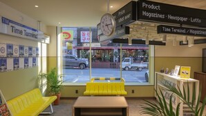 Een Time Terminal met een gele bank, een klok en uitzicht op de straat.