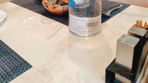 A bottle of water on a table in a restaurant setting. - Four Leaf Hotel Akosha (Varanasi)