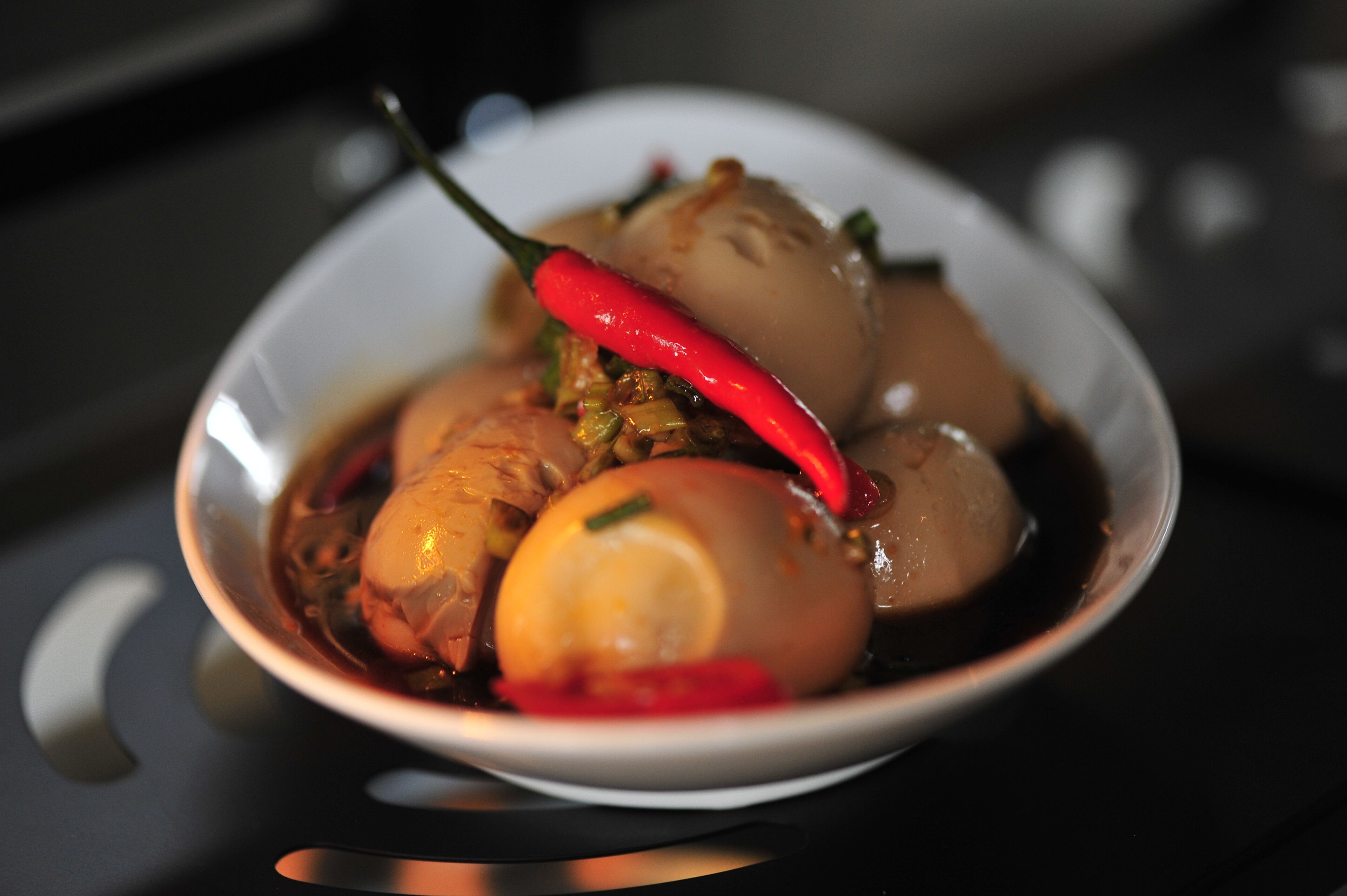 A bowl of food with a red chili and a boiled egg.