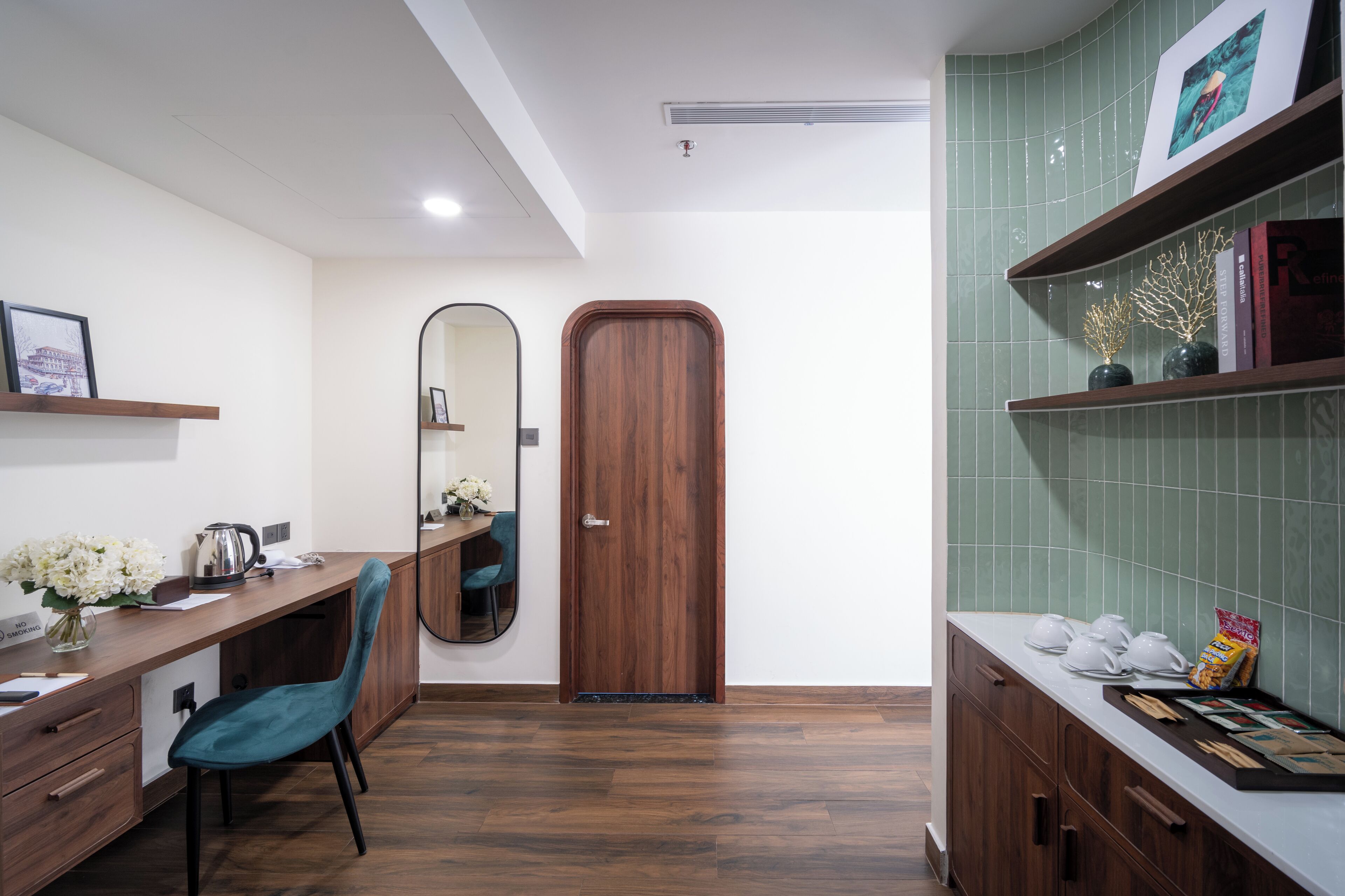 Une cuisine moderne avec un plan de travail en bois, une chaise de couleur turquoise, une porte en bois et un pare-feu en carreaux verts.