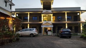 A two-story building with a central entrance, a sign reading "O' Nest Countryside," and two cars parked in front. - O'NEST Countryside (Murud)