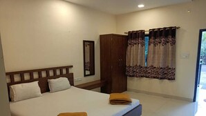 A bedroom with a large bed, a wardrobe, and a window with curtains. - O'NEST Countryside (Murud)