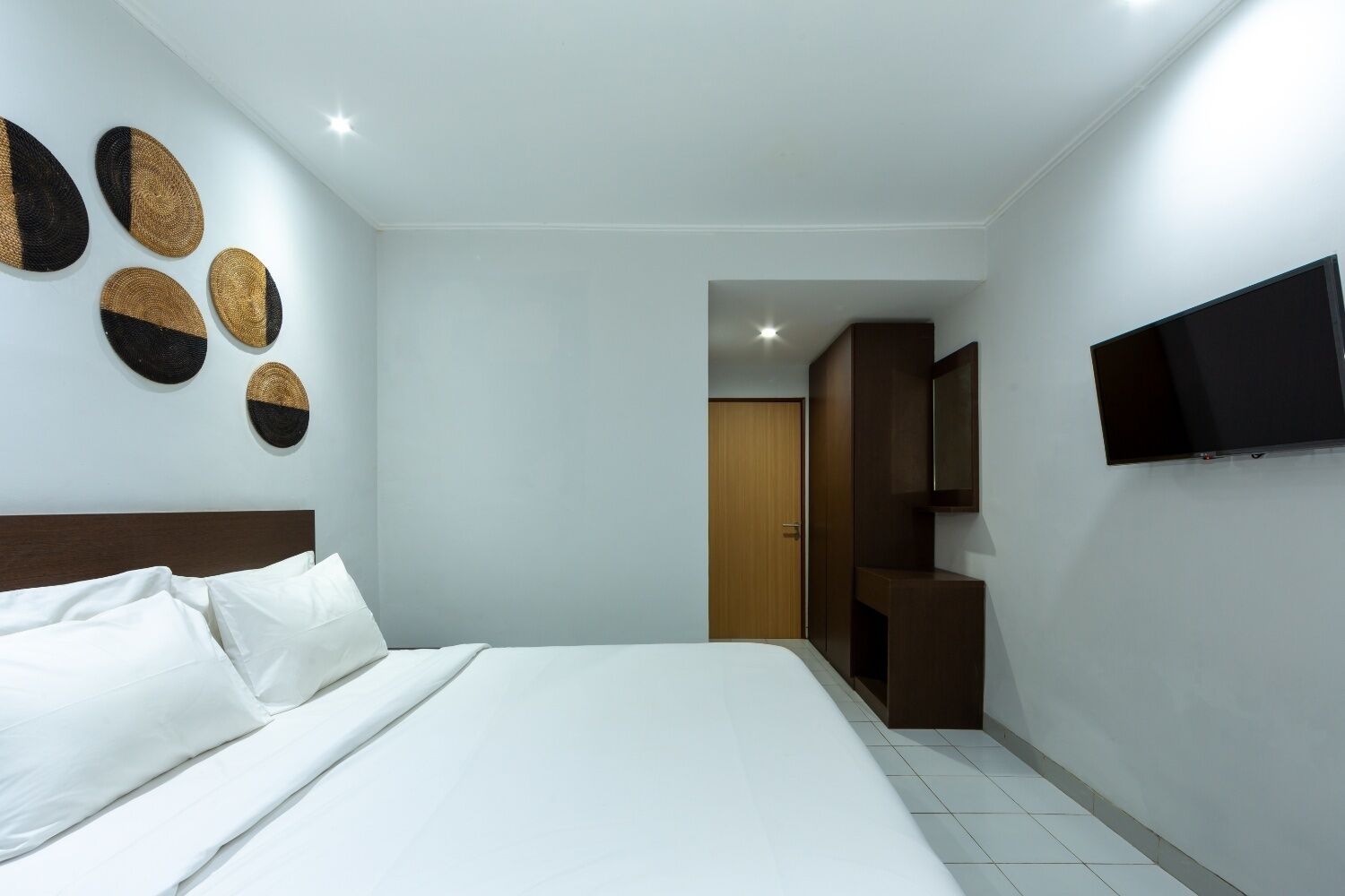 A hotel room with a bed, a TV, and a wardrobe.