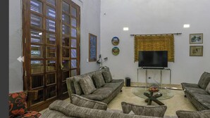 Ein Wohnzimmer mit zwei Sofas, einem Couchtisch, einem Fernseher und einem Bücherregal.