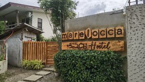 A hostel named "marellocca" with a wooden sign and a concrete wall. - Marelocca Beach House  (Calatagan)
