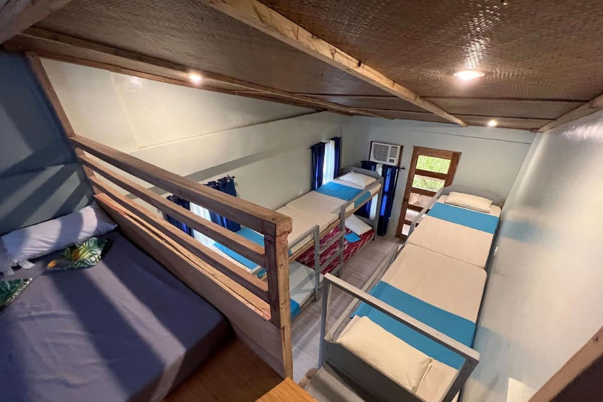 A compact, well-lit cabin with bunk beds, a small kitchenette, and a window providing natural light.