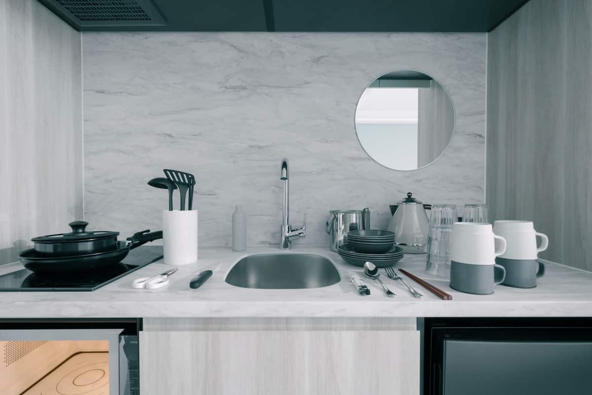 A modern kitchen with a sink, stove, and various utensils.