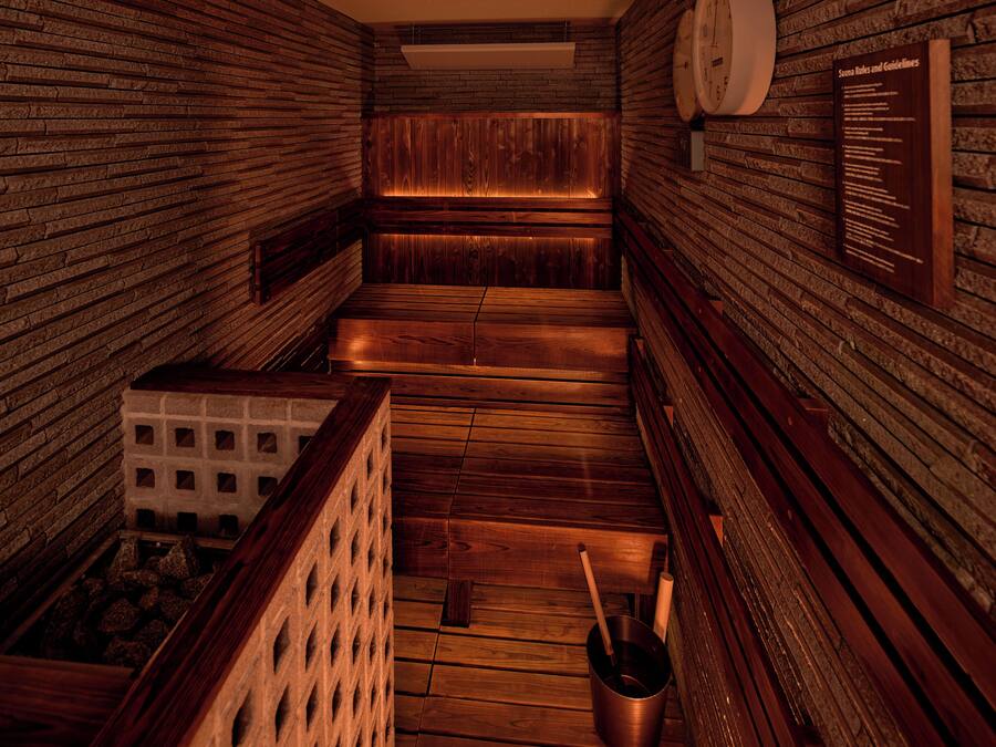 Una sauna con bancos de madera y una pared de ladrillo.