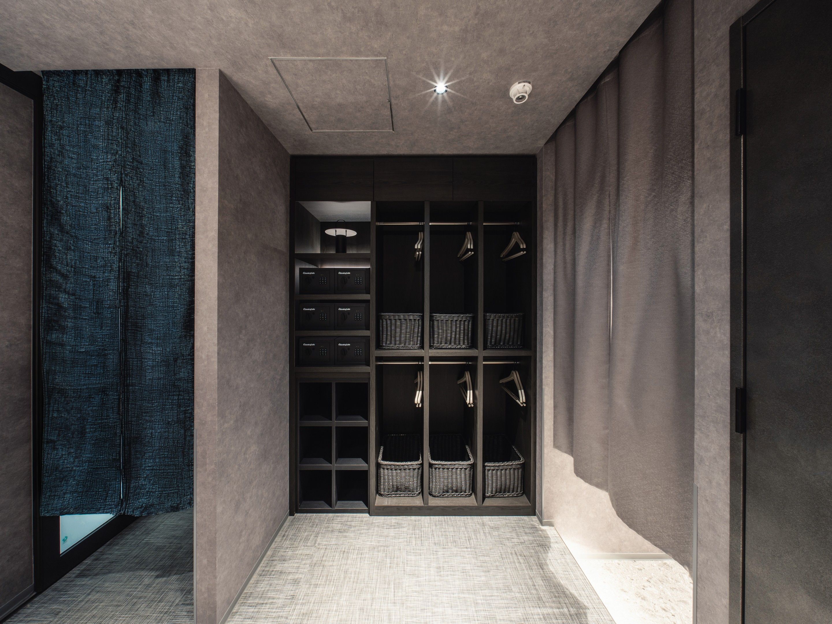 A modern interior with a built-in wardrobe, shelves, and a patterned wall.