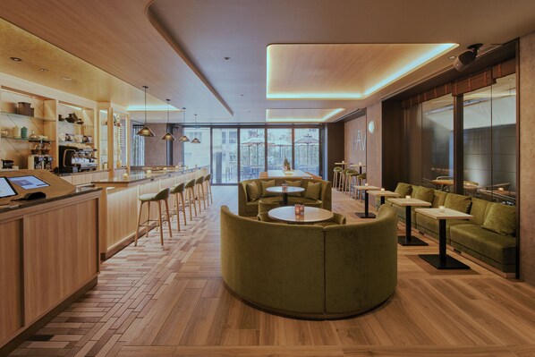 A modern interior with a bar area, seating with round tables, and a view through large windows. - FAV LUX NAGASAKI (Nagasaki)