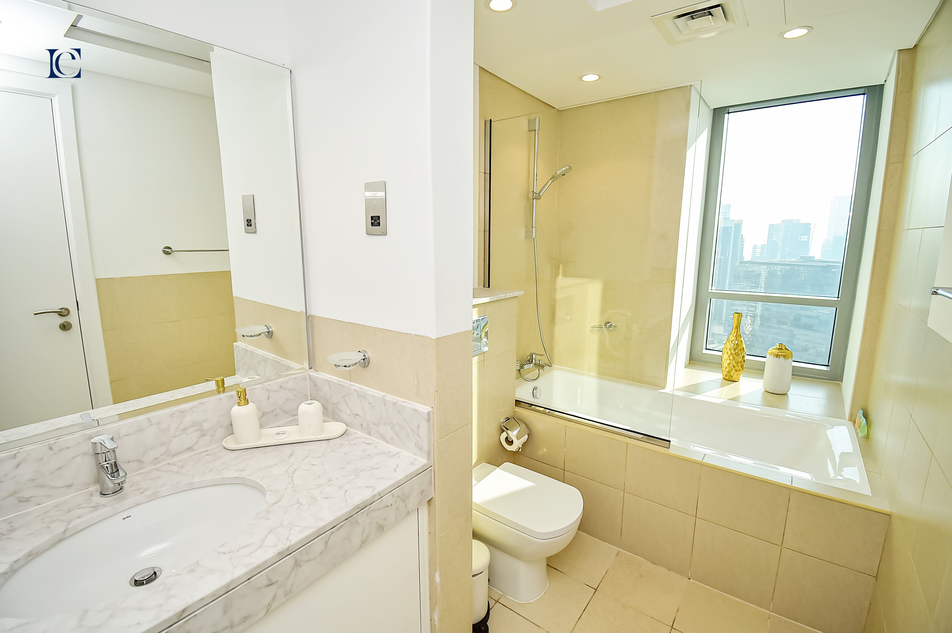 Une salle de bain moderne avec un lavabo en marbre, une cabine de douche en verre et des toilettes.