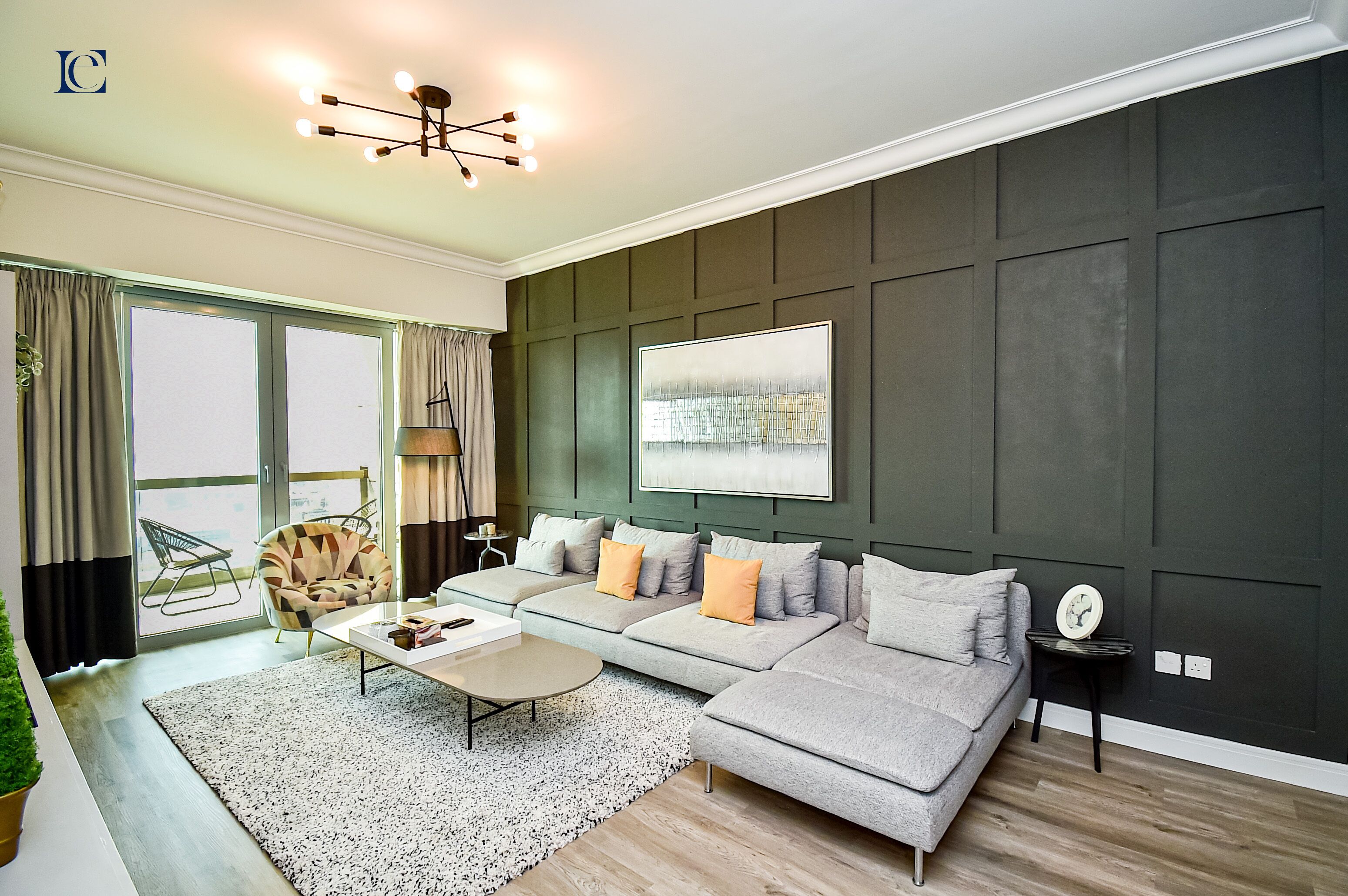 A modern living room with a sectional sofa, a coffee table, and a large window with curtains.