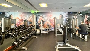 A gym with various exercise equipment, including dumbbells, a bench press, and a squat rack. - New 1BR Apartment - 8 Blvd Walk -  WLK (Dubai)