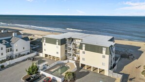 Un hôtel situé en bord de mer, composé de plusieurs bâtiments, doté d’une piscine et offrant une vue sur l’océan.