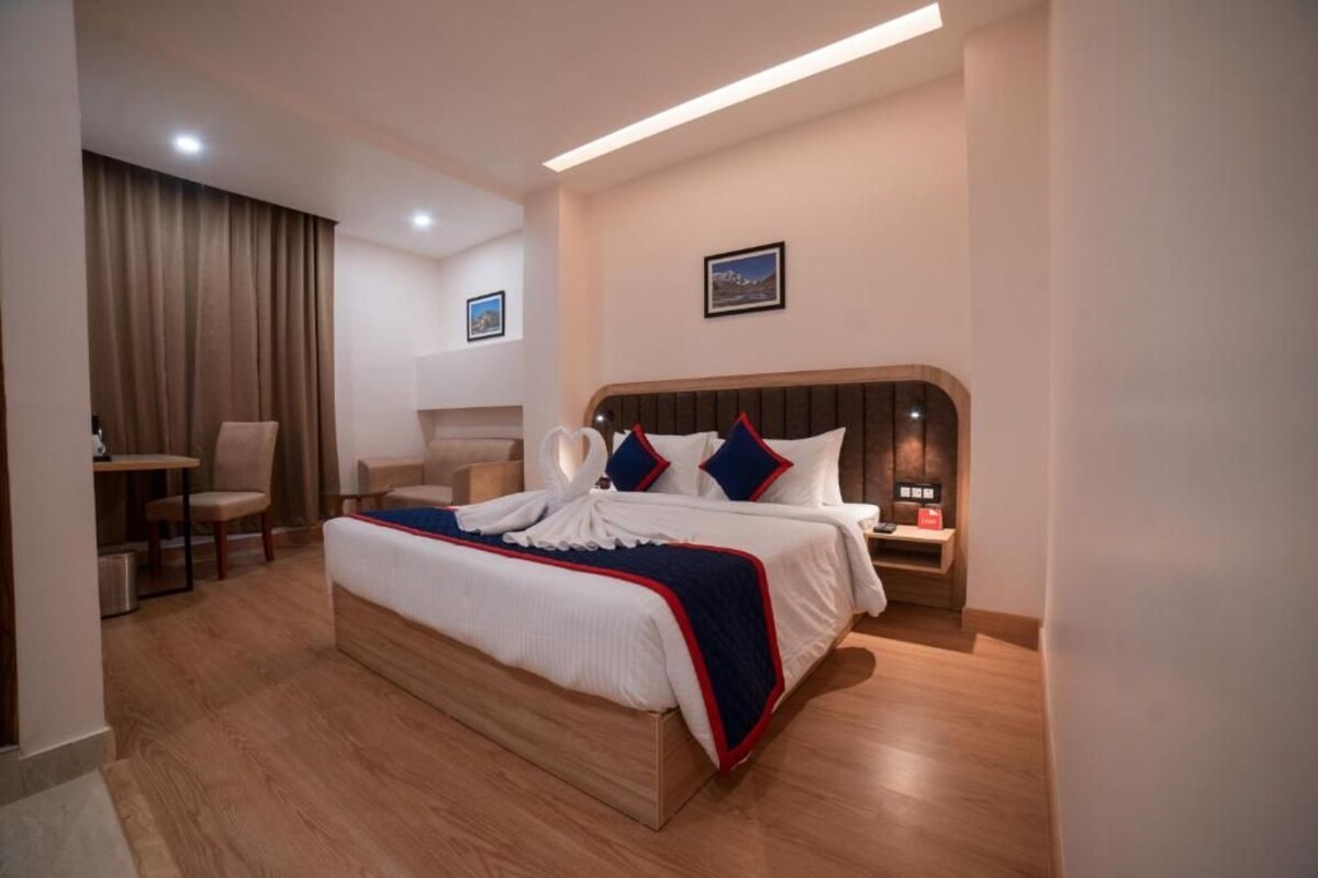 Une chambre d’hôtel avec un grand lit, un bureau et une chaise.