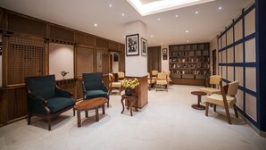 A spacious lobby with wooden paneling, a reception desk, multiple seating areas, and a bookshelf. - Zip By Spree Hotels Gangtok (Gangtok)