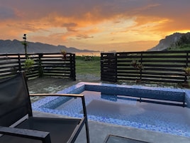 Zona de piscina con vistas a montañas y al atardecer.