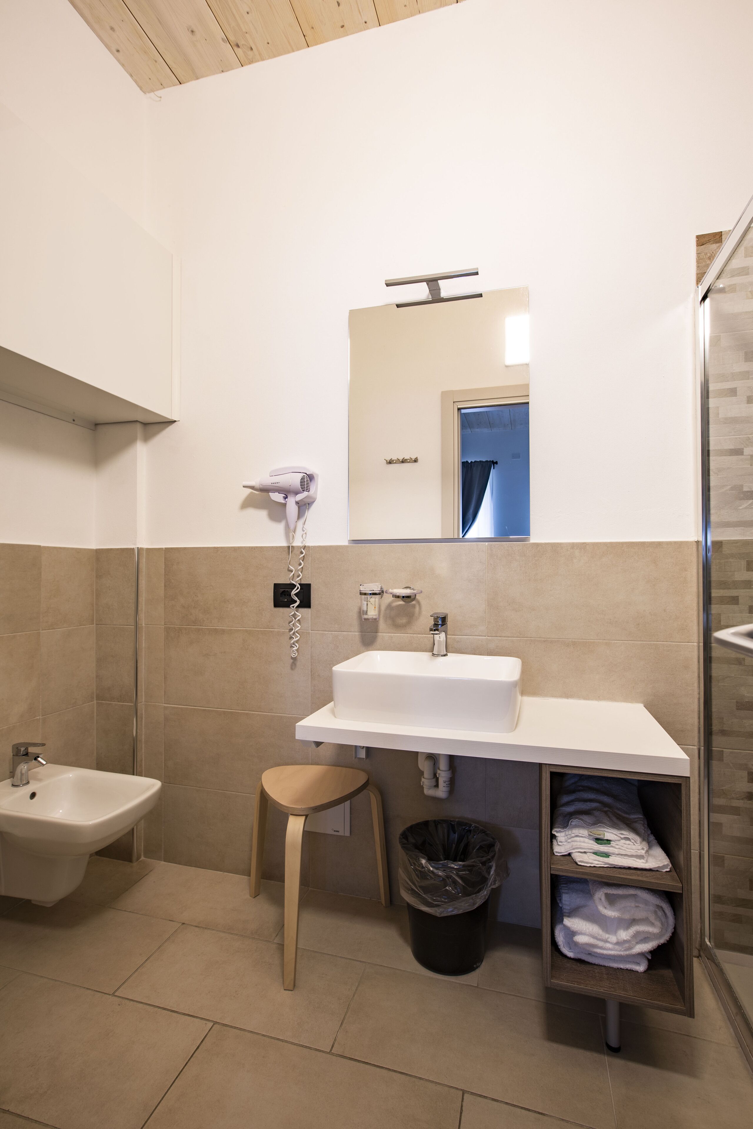 Une salle de bain moderne équipée d’un lavabo, d’un meuble-vasque, d’un miroir et d’une douche.