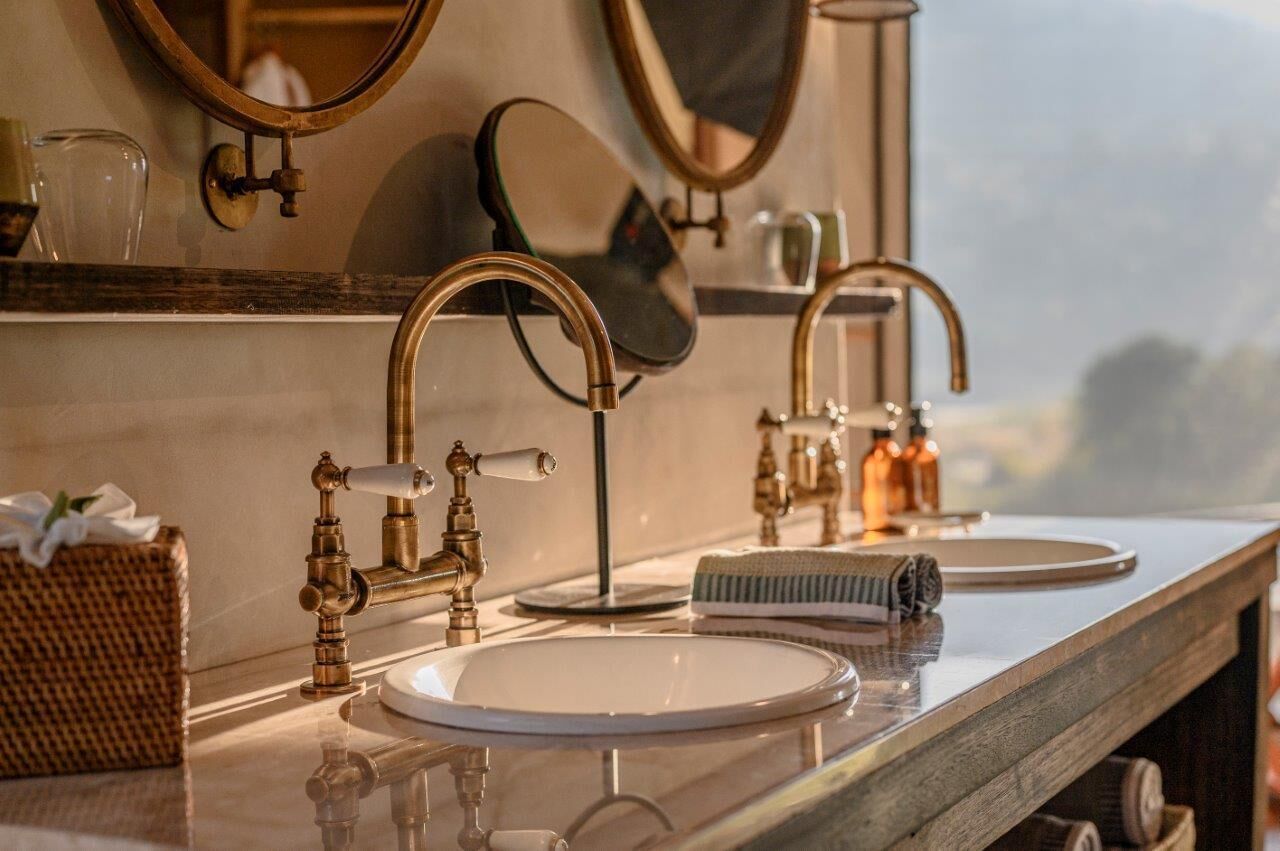 Un bagno con due lavabi, uno specchio e un porta asciugamani.