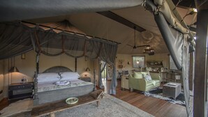 Un dormitorio amplio con una cama grande, un banco de madera, un escritorio y un sillón verde.