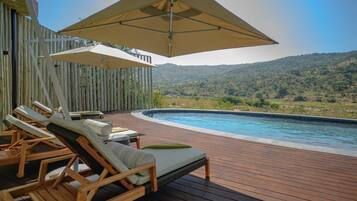 Een buitenzwembad, parasols voor strand/zwembad