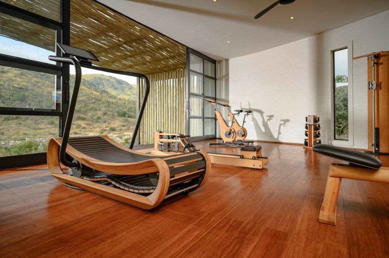 A spacious room with a large window, a wooden exercise bike, and a massage chair.
