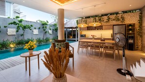 Un intérieur moderne avec une piscine, un coin repas et une cuisine.
