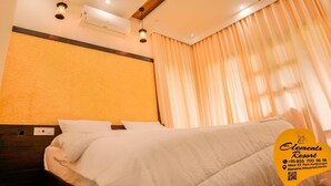 A hotel room with a bed, wooden ceiling beams, an air conditioning unit, and a curtain. - Elements Resort (Mananthavady)