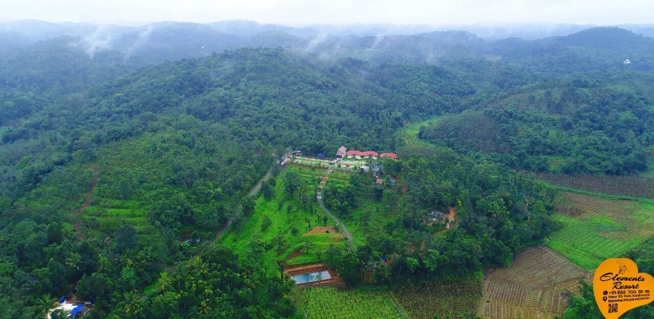 Vista aérea de un resort rodeado de vegetación exuberante y campos escalonados.