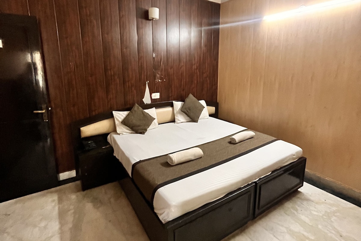 A neatly arranged bedroom with a bed, bedside tables, a ceiling fan, and a wall-mounted light fixture.