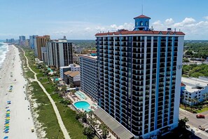 A high-rise hotel with a rooftop pool, beach access, and a view of the ocean. - Beachside Haven: Double Suites with Ocean Views (Myrtle Beach)