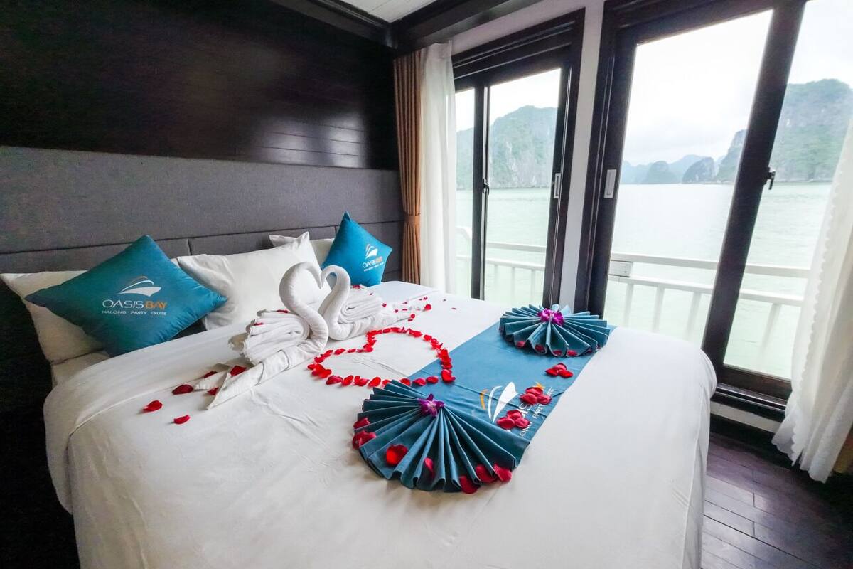 A hotel room with a bed, pillows, and a view of the water.