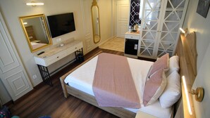 A hotel room with a bed, a TV, a mirror, a wardrobe, and a desk. - SUR PALACE HOTEL (Diyarbakir)