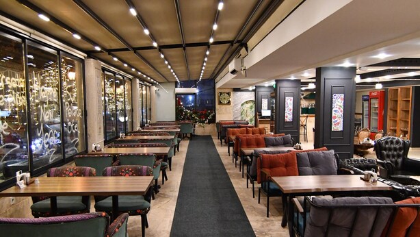 A restaurant with a long central aisle, booths, and tables. - SUR PALACE HOTEL (Diyarbakir)