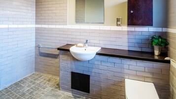 A bathroom with a white sink, a toilet, and a mirror above the sink.