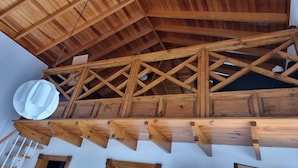 Struttura del soffitto in legno con travi e lampadario.
