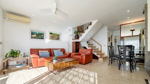 A spacious living area with a sofa, coffee table, and dining table. - Holiday Home 'Ca La Montse' with Sea View, Private Terrace and Wi-Fi (Altafulla)