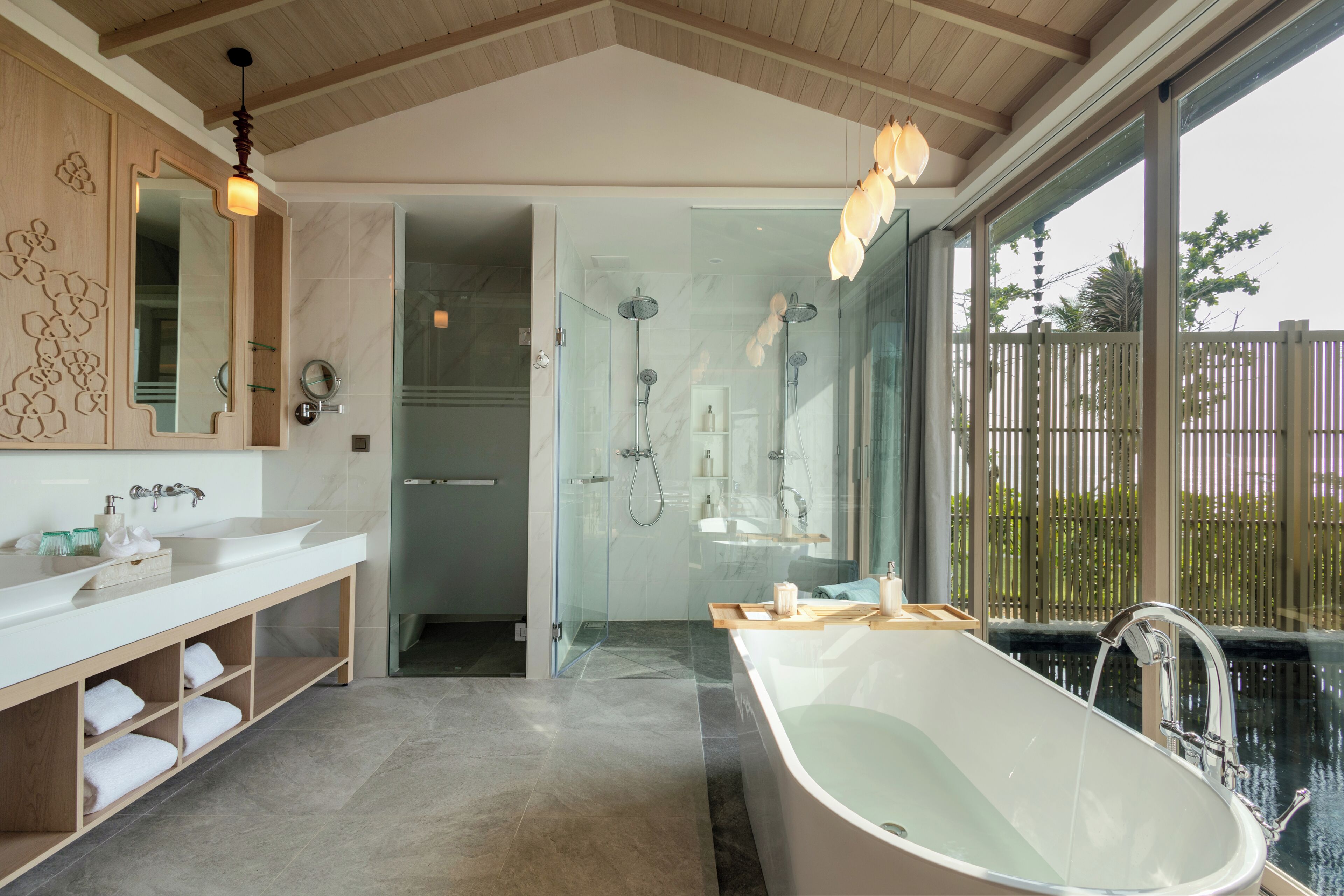 A modern bathroom with a large bathtub, a glass-enclosed shower, and a vanity with a mirror.