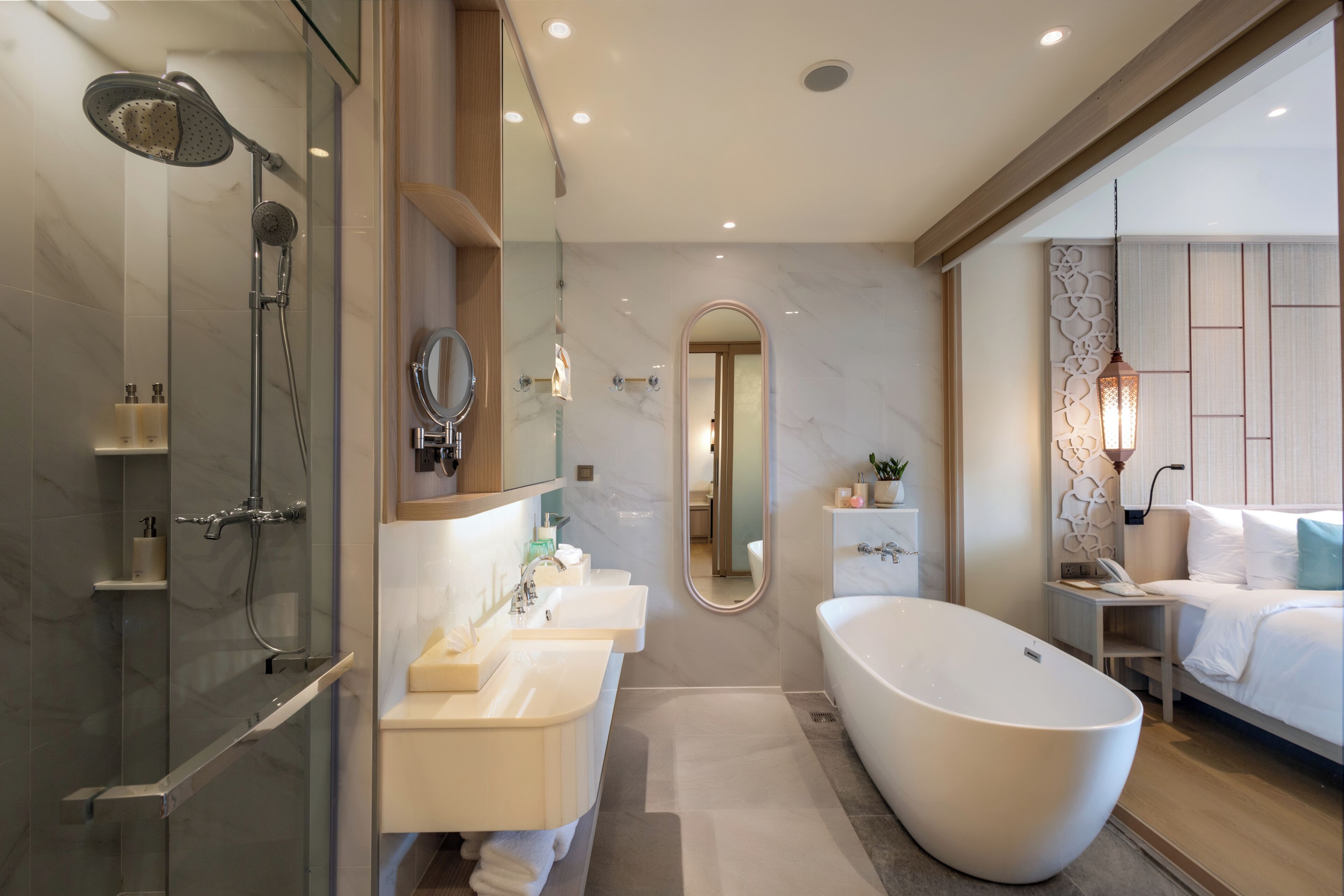Ein modernes Badezimmer mit einer gläsernen Duschkabine, einer freistehenden Badewanne und einem Waschtisch mit zwei Becken.